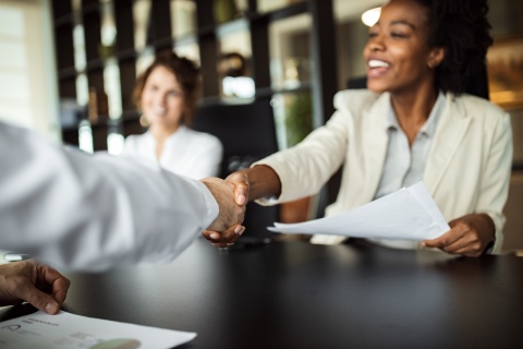 Professionals shaking hands across a table
