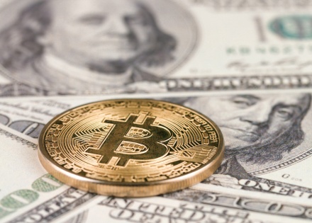 Bitcoin on top of US dollar bills.
