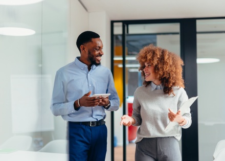 Two business colleagues walking and discussing payroll tax in Papua New Guinea