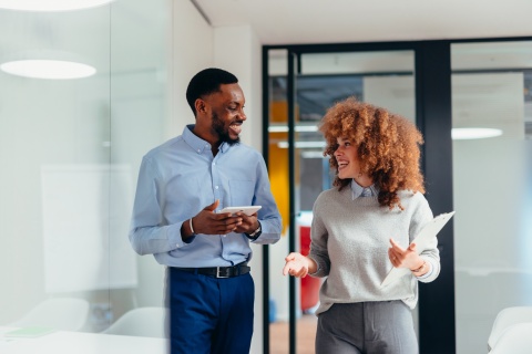 Two business colleagues walking and discussing payroll tax in Papua New Guinea