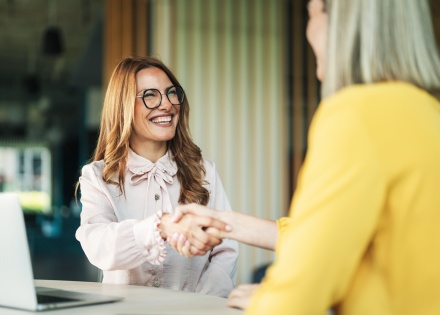 Business professionals shake hands after discussing salary in Estonia