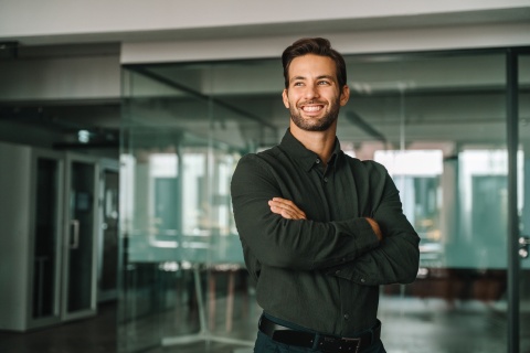Businessman standing crossed arms in office in Moldova