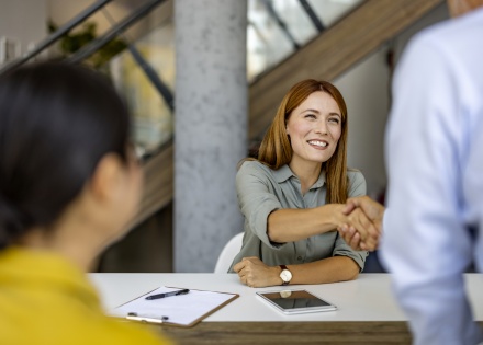 Businesswoman shaking hands with colleague after discussing salary in Mauritania