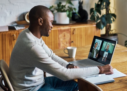 Man smiling while on a video call on his laptop