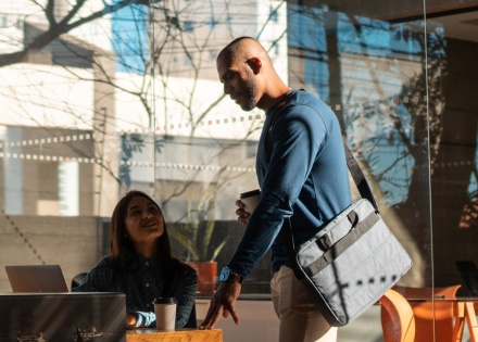 Two remote workers talking at an outdoor café table on the city streets of Brazil
