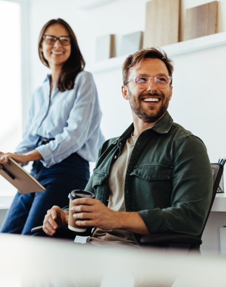 Three colleagues in bright meeting room smiling regarding global expansion.