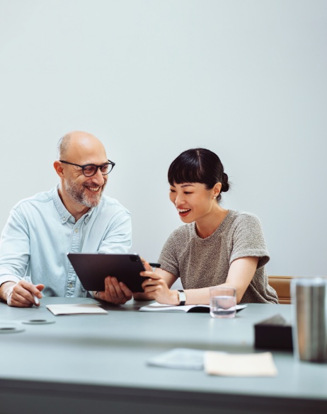 Male and female colleagues reviewing Pebl M&A on tablet.