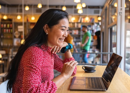 Woman smiling while looking at her laptop screen