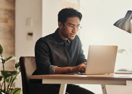Remote employee works on his laptop from home
