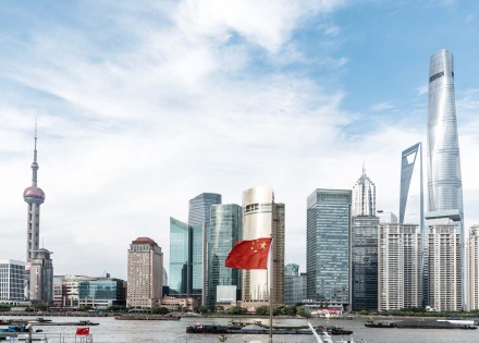 Shanghai, China skyline, Chinese flag at full staff in the center.