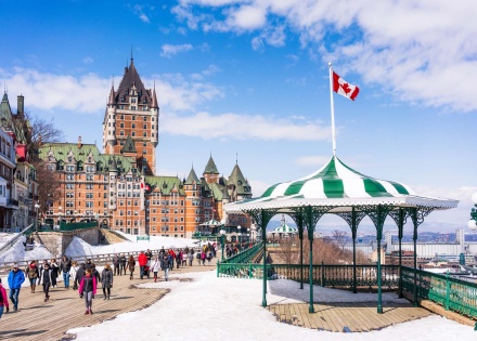 Candian city, snow on the ground, Canadian flag blowing in the wind