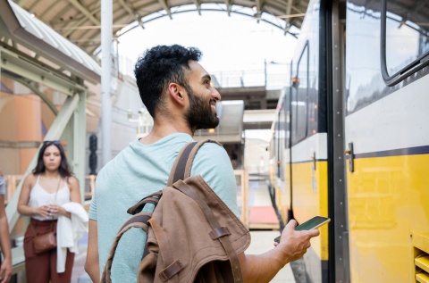 Young man standing on train station platform in India.