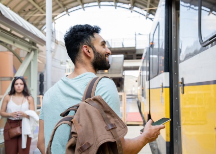 Young man standing on train station platform in India.