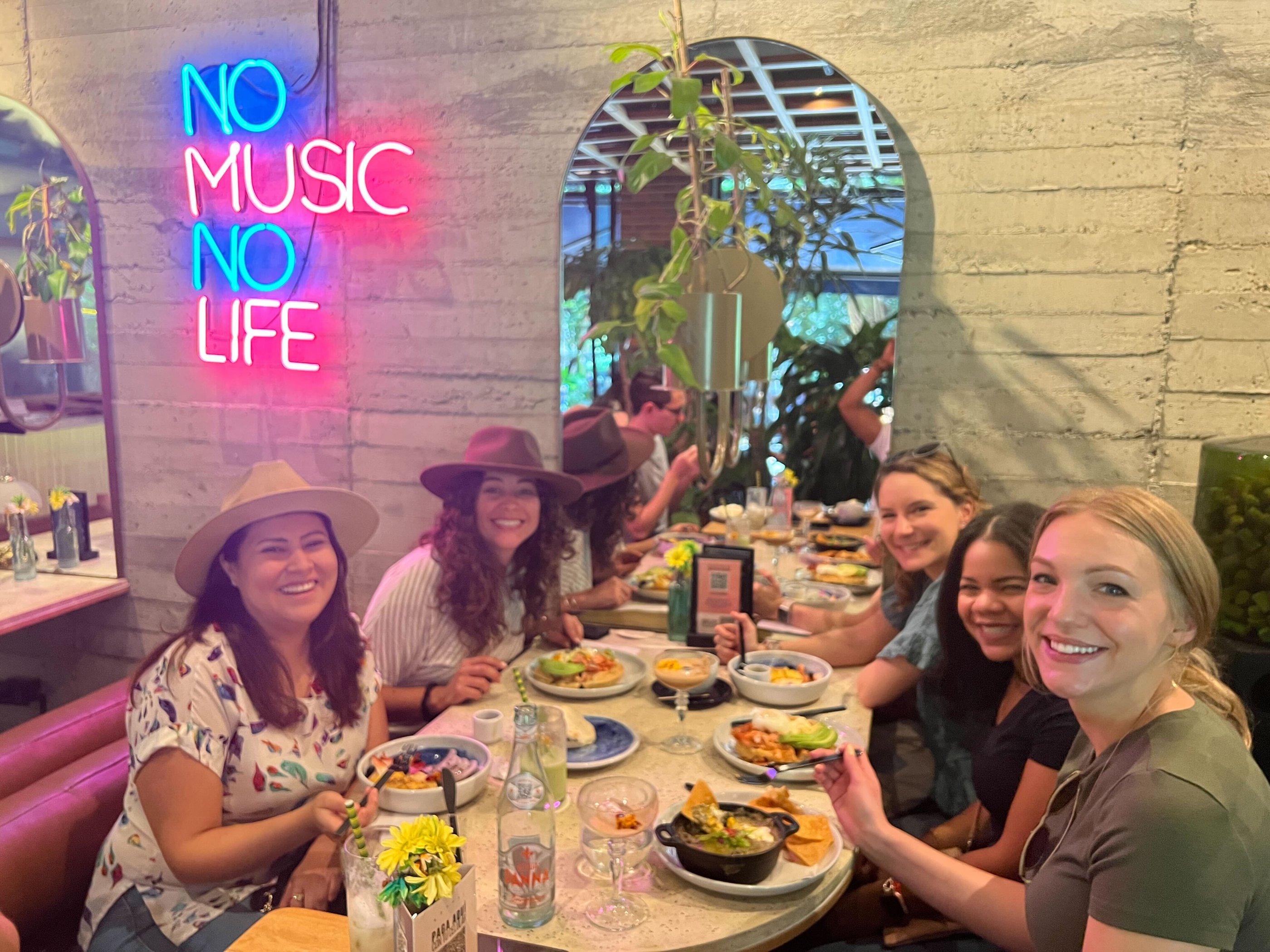 Group of co-workers sitting at a dinner table with their food and drinks