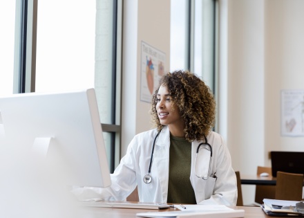 Doctor looks over patient records at her computer