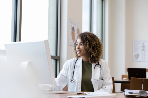 Doctor looks over patient records at her computer