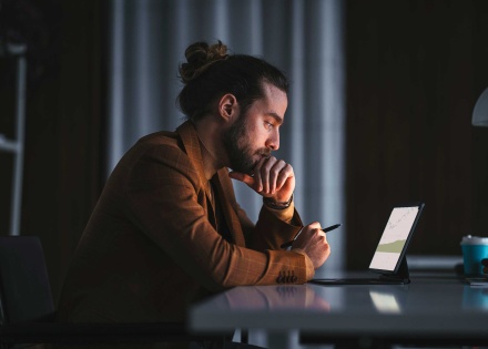Man working on a laptop in a dark room