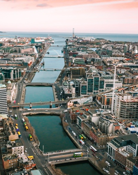 Zoomed out city-scape under construction with large river running between.