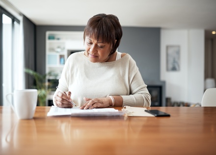 Mature woman at home working through payroll taxes in Jordan