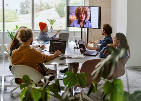 Six colleagues in a conference room discussing payroll outsourcing
