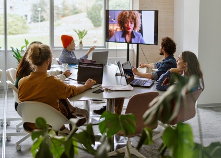 Six colleagues in a conference room discussing payroll outsourcing