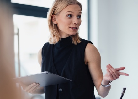 Professional woman in office setting providing HR strategy for hiring freezes.