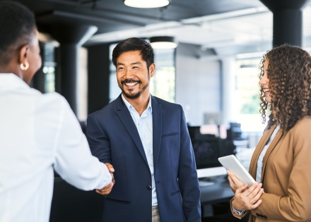 Smiling businessman shaking hands with colleague after discussing salary in Liberia