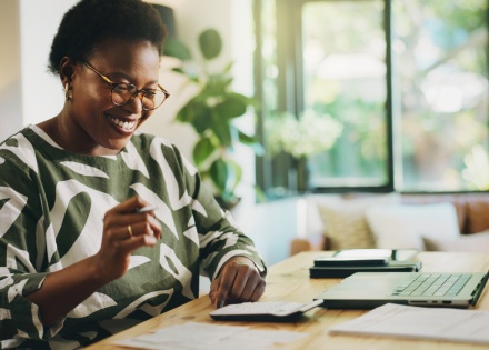 Smiling woman working with laptop for payroll taxes in Cambodia