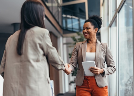 Two businesswomen shaking hands after discussing salary in Malawi