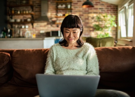 Woman accepts payment in crypto on her laptop at home