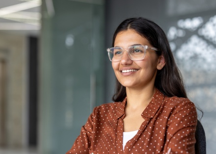 Woman with glasses smiling in an office in Jamaica