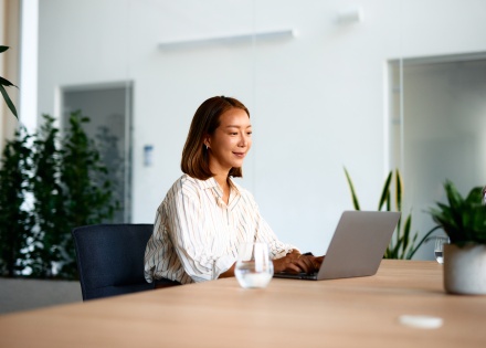 Young businesswoman working on laptop in modern office