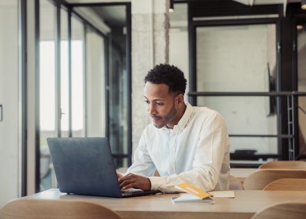 Young man using his laptop while working in his office