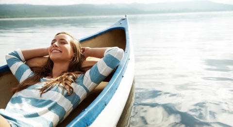 Woman enjoying her paid vacation days relaxing in a canoe