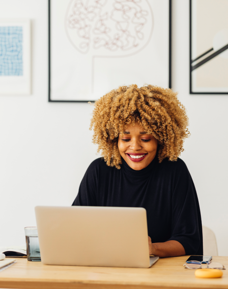 Woman sitting at kitchen table working on a laptop