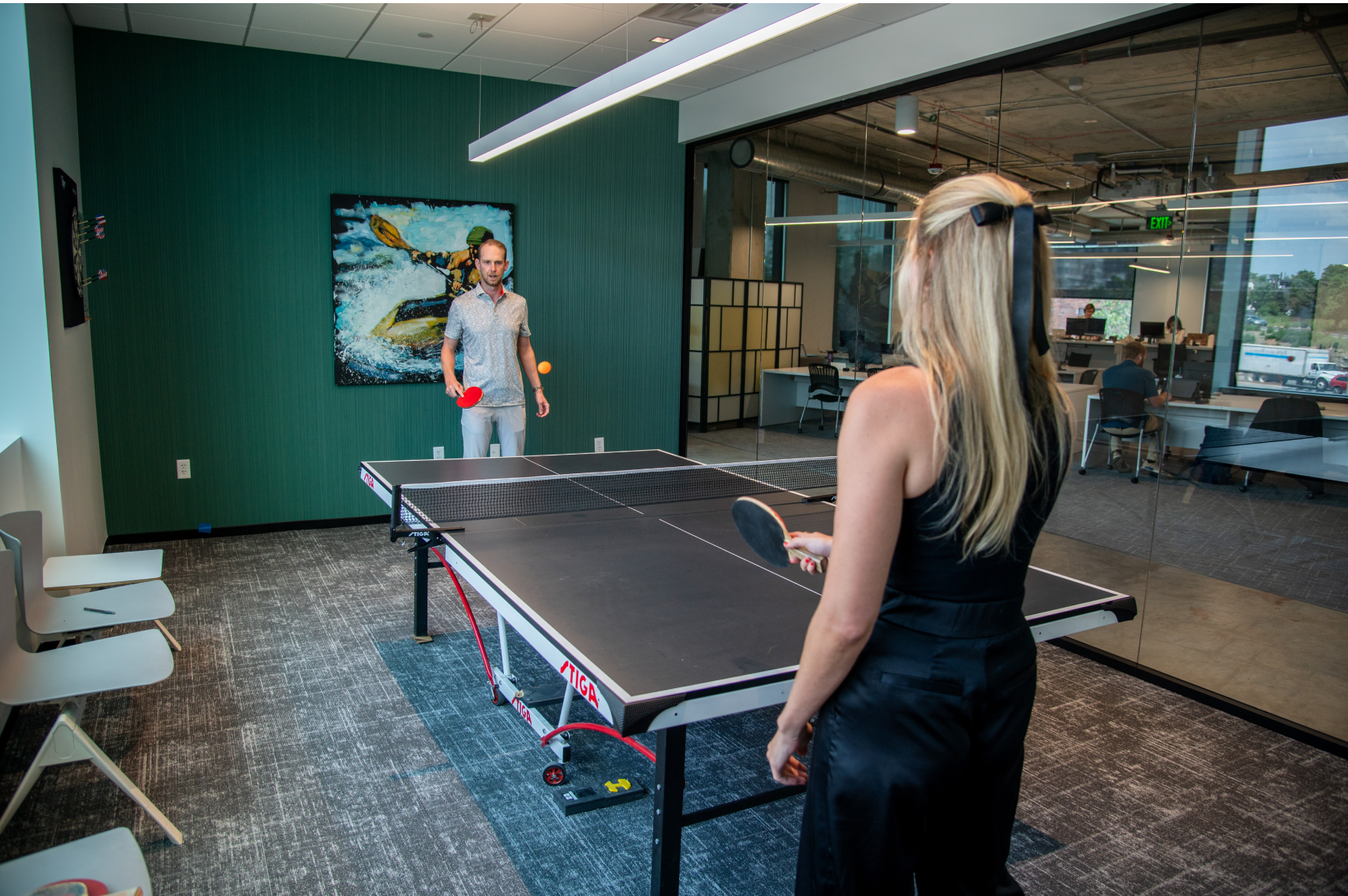 Pebl team members playing ping pong in the Badlands game room. 