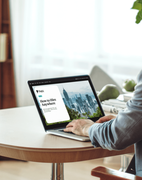 Person looking at How to Hire Anywhere guide on laptop.