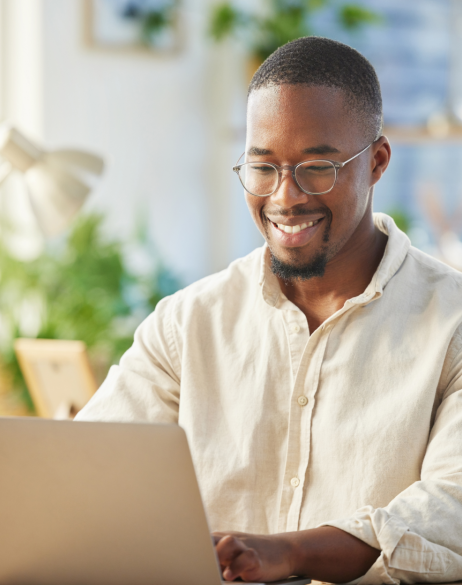 Smiling man using laptop at home
